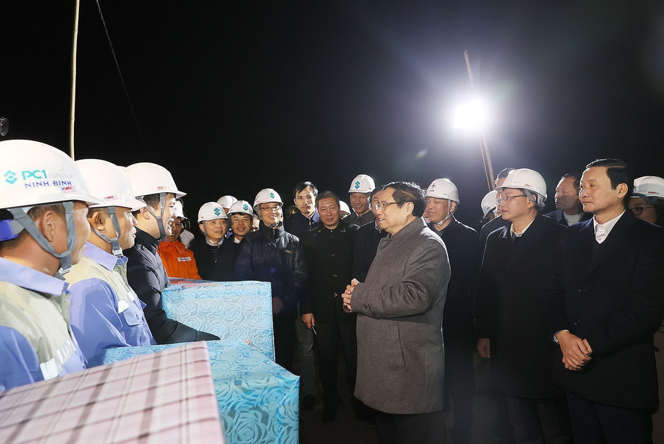 Thủ tướng Phạm Minh Chính tặng quà động viên công nhân thi công Dự án Đường dây 500kV Nam Định 1-Thanh Hóa. (Ảnh: Dương Giang/TTXVN)