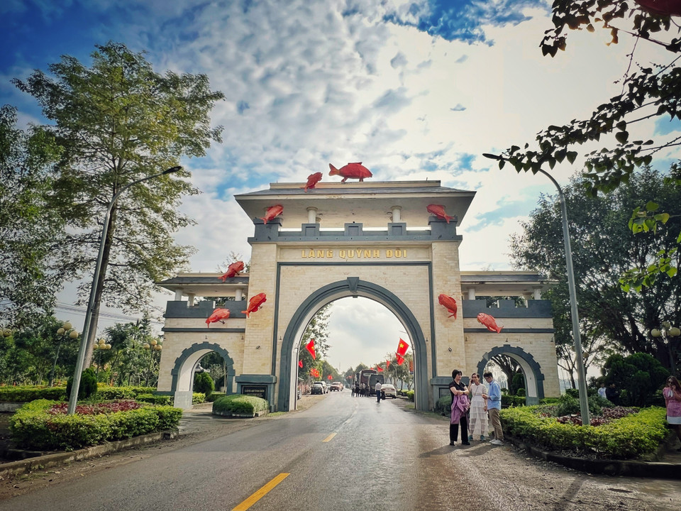 Tìm về “làng cá gỗ” (xã Quỳnh Đô, huyện Quỳnh Lưu, tỉnh Nghệ An), du khách sẽ vô cùng bất ngờ với hình ảnh “Cá chép vượt vũ môn” thể hiện tinh thần của người làng Quỳnh vượt khó thành tài. Cổng làng cũng chính là nơi cụ Nguyễn Sinh Sắc, cụ cả Khiêm và cậu bé Nguyễn Sinh Cung đã rời làng từ hơn 100 năm trước. (Ảnh: Mai Mai/Vietnam+)