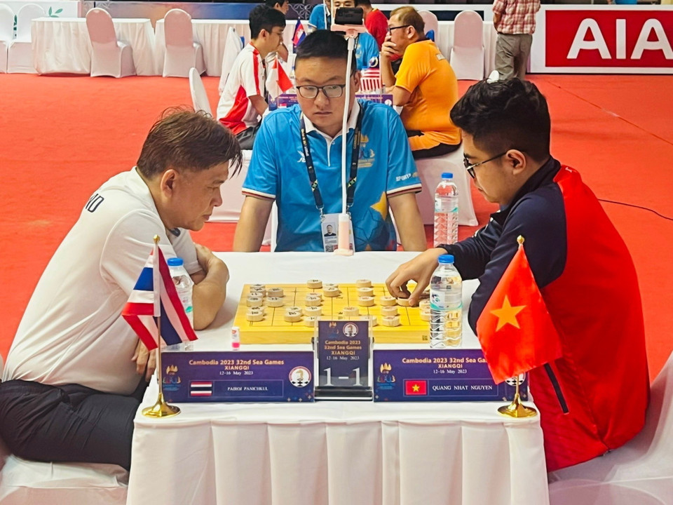 Vận động viên Nguyễn Quang Nhật (áo đỏ, phải) thi đấu nội dung Cờ nhanh đồng đội nam và cùng Đặng Cửu Tùng Lân giành tấm huy chương Vàng thứ 2 cho đội tuyển Cờ tướng. (Ảnh: TTXVN)