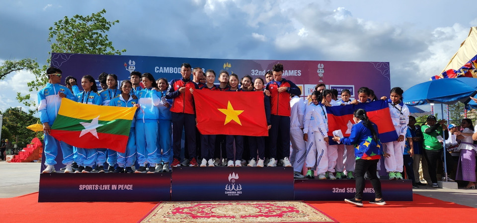 Đội tuyển Đua thuyền Việt Nam (giữa) nhận huy chương Vàng Đua thuyền truyền thống nội dung thuyền 12 người hỗn hợp cự ly 500m - tấm huy chương Vàng thứ 2 của Đội tại SEA Games 32. (Ảnh: TTXVN) 