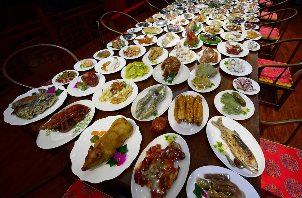 Khách mời ngắm các món ăn tại bàn đại tiệc trăm món bằng đá quý trưng bày tại Phúc Châu, Trung Quốc. (Ảnh: THX/TTXVN)