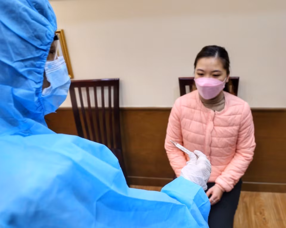 Tình huống kiểm tra lại nhiệt độ lần nữa cho học sinh có thân nhiệt cao.(Ảnh: Tuấn Đức/TTXVN)