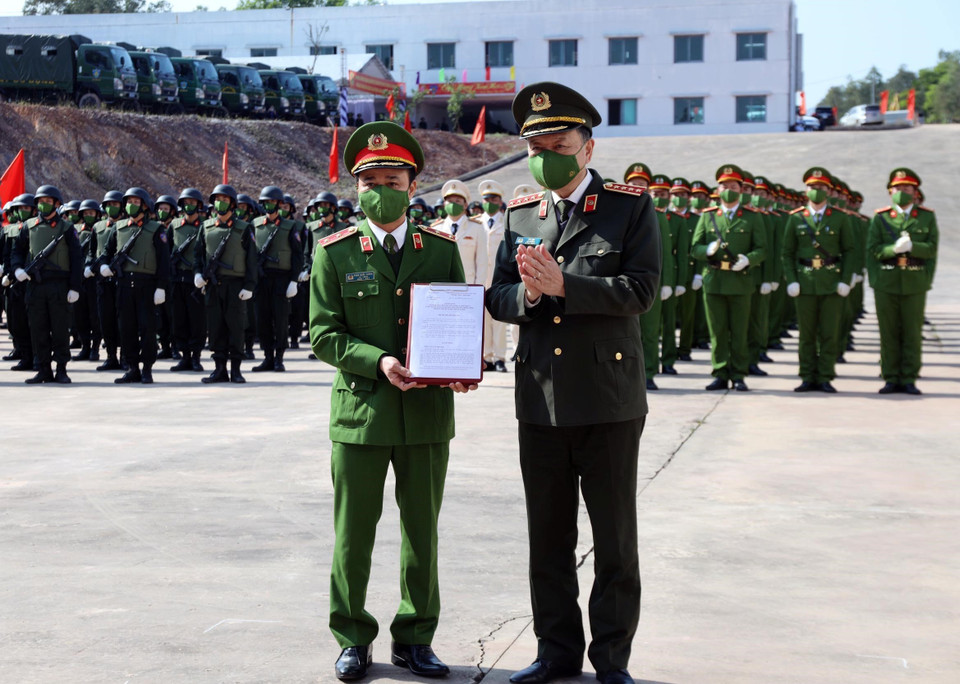Đại tướng Tô Lâm, Ủy viên Bộ Chính trị, Bộ trưởng Bộ Công an trao quyết định thành lập Trung tâm cho Trung tướng Phạm Quốc Cương, Tư lệnh Bộ Tư lệnh CSCĐ. (Ảnh: TTXVN phát)