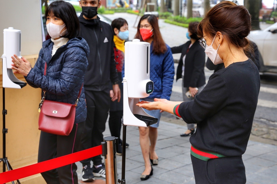 Học sinh sát khuẩn và đo thân nhiệt trước khi vào trường. (Ảnh: Tuấn Đức/TTXVN)