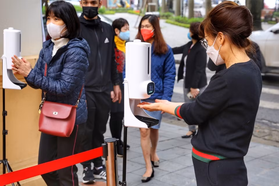 Học sinh sát khuẩn và đo thân nhiệt trước khi vào trường. (Ảnh: Tuấn Đức/TTXVN)