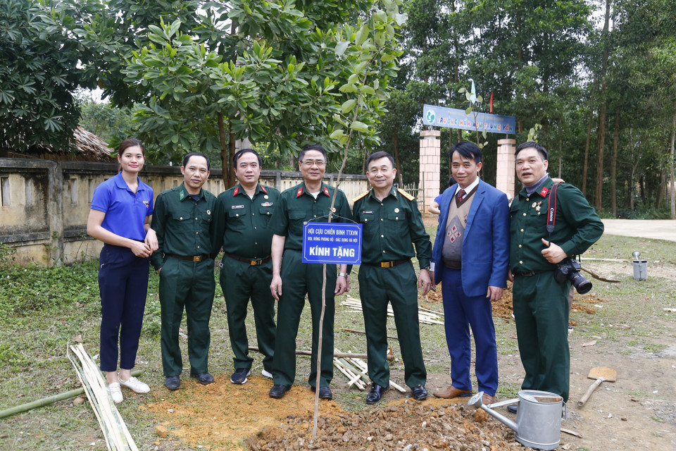 Đoàn cán bộ Hội CCB TTXVN chụp ảnh lưu niệm với cán bộ, giáo viên trường Tiểu học Tôn Đức Thắng. (Ảnh: Nam Sương /TTXVN)