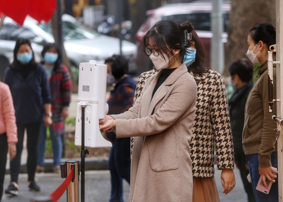 Học sinh sát khuẩn và đo thân nhiệt trước khi vào trường. (Ảnh: Tuấn Đức/TTXVN)