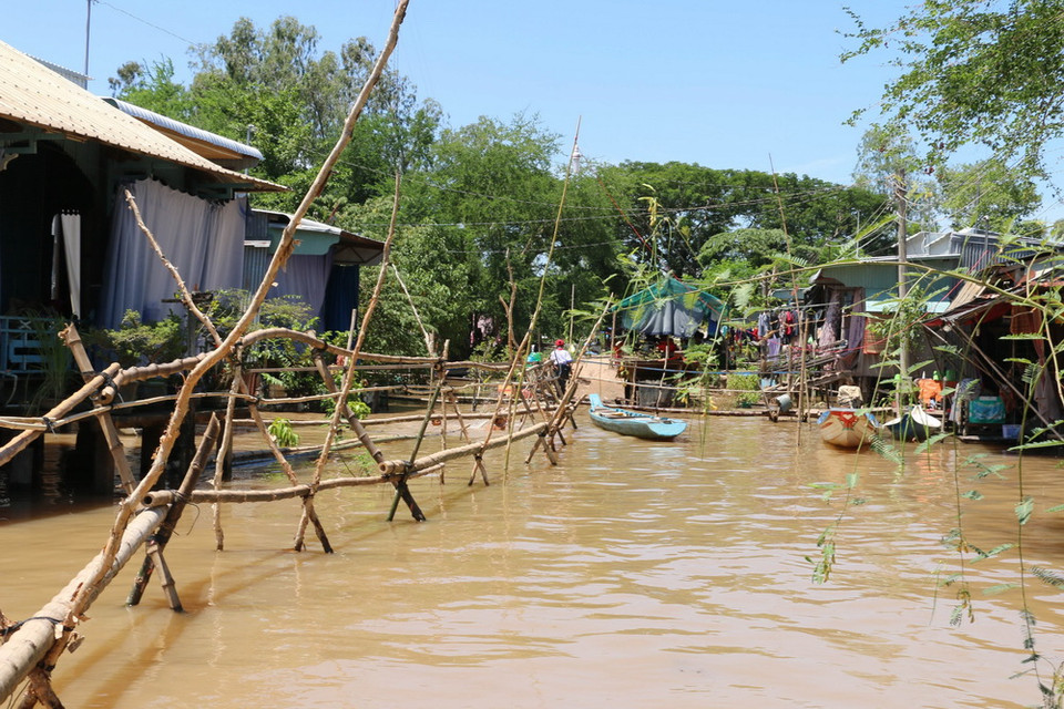 Nhiều em còn phải băng qua cây cầu khỉ khá dài mới vào được nhà. (Ảnh: Công Mạo/TTXVN)