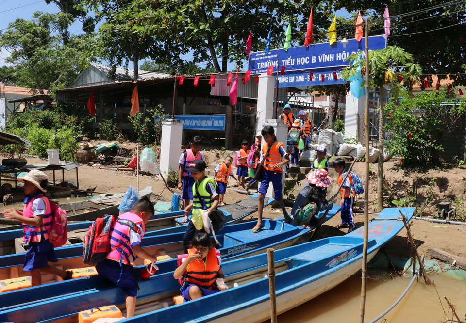 Các em học trinh Trường tiểu học B Vĩnh Hội Đông ở 2 ấp Vĩnh Hòa và Vĩnh An sau khi tan học xuống xuồng chuẩn bị về nhà. (Ảnh: Công Mạo/TTXVN)