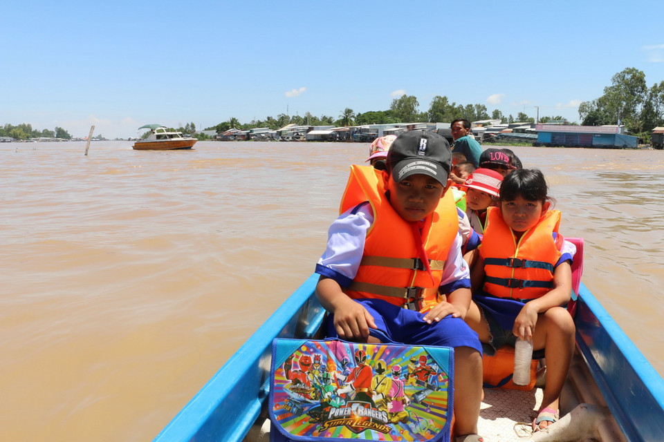 Các em học sinh Trường Tiểu học B Vĩnh Hội Đông ở 2 ấp Vĩnh Hòa và Vĩnh An, dọc theo kênh Ngọn Cả Hàng sau khi tan học được anh Trần Văn Hiền - chiến sỹ dân quân tự vệ xã Vĩnh Hội Đông lái vỏ lãi (xuồng) đưa về tận nhà.(Ảnh: Công Mạo/TTXVN)