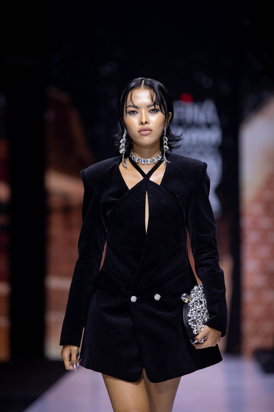 Trắng, đen, beige là những tông màu chủ đạo của bộ sưu tập đan xen tông màu vàng, tím nổi bật, cùng các chi tiết cắt xẻ, corset, blazer độn vai cũng như tạo hình đôi lông mày đính cườm đã phần nào thể hiện vẻ mạnh mẽ, đanh thép của những người phụ nữ hiện đại, dám thể hiện cá tính. (Ảnh: CTV/Vietnam+)