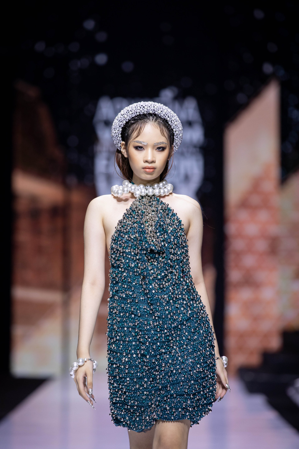 Bên cạnh những phụ kiện ví, túi xách... được chăm chút, đính cườm và kết đá tỉ mỉ, Nguyễn Tiến Truyển còn thể hiện sáng tạo khi kết hợp những chi tiết đậm chất truyền thống Bắc Bộ như mấn, nón quai thao và khăn mỏ quạ, thổi hồn bằng những đính kết đá hiện đại đầy bất ngờ. (Ảnh: CTV/Vietnam+)