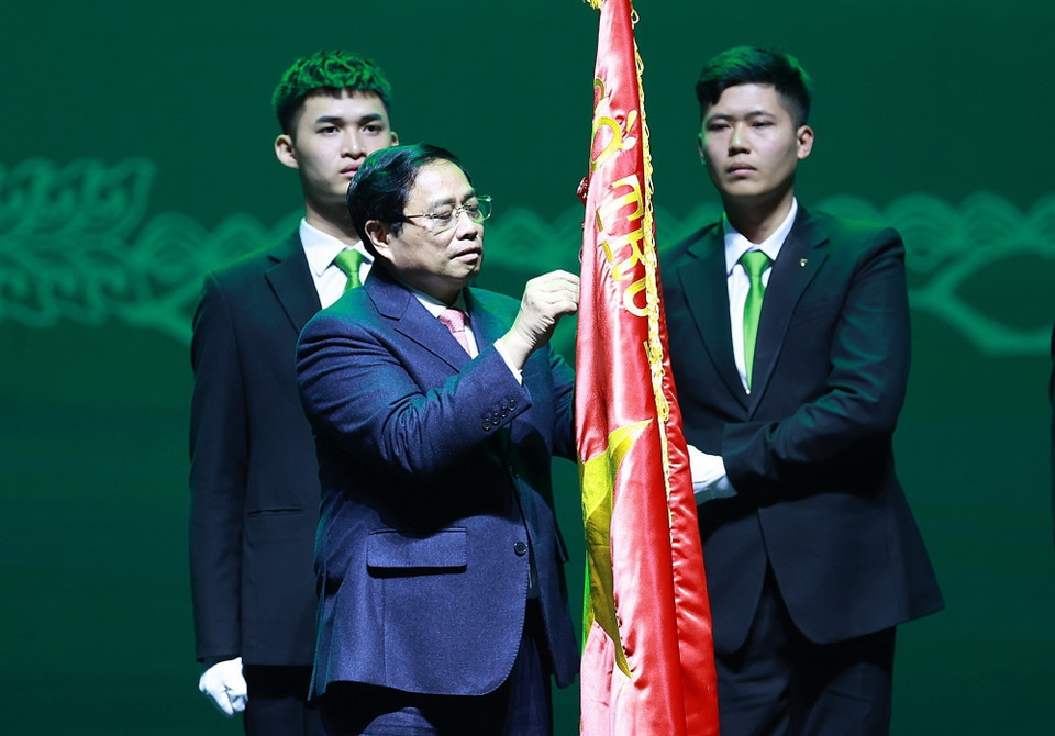 Thủ tướng Phạm Minh Chính gắn Danh hiệu Anh hùng Lao động lên cờ truyền thống Ngân hàng thương mại cổ phần Ngoại thương Việt Nam. (Ảnh: Dương Giang/TTXVN)