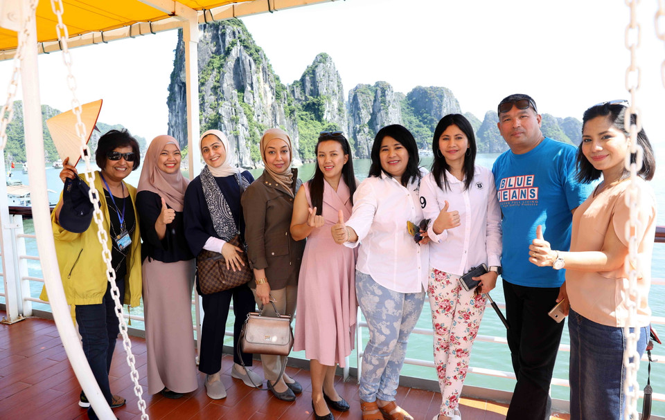 Các đại biểu chụp ảnh kỷ niệm trên tàu đi tham quan Vịnh Hạ Long. (Ảnh: TTXVN)