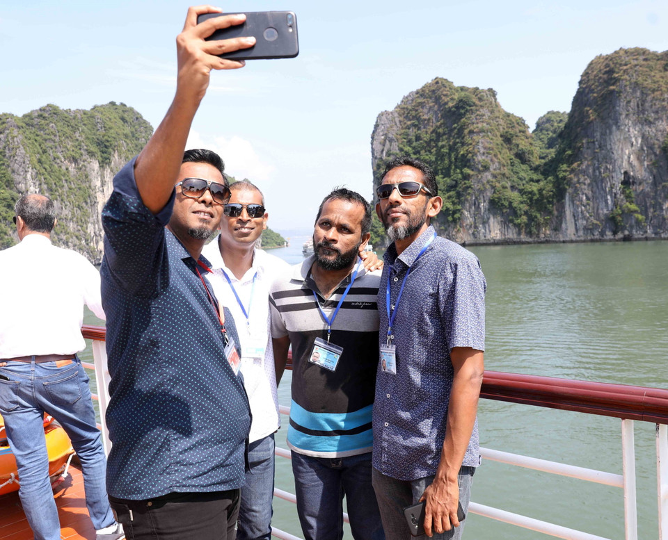 Các đại biểu chụp ảnh kỷ niệm trên tàu đi tham quan Vịnh Hạ Long. (Ảnh: TTXVN)