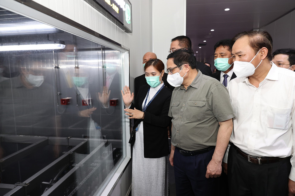 Thủ tướng Phạm Minh Chính xem quy trình chế biến thịt gia cầm xuất khẩu của Công ty CPV Food. (Ảnh: Dương Giang/TTXVN)