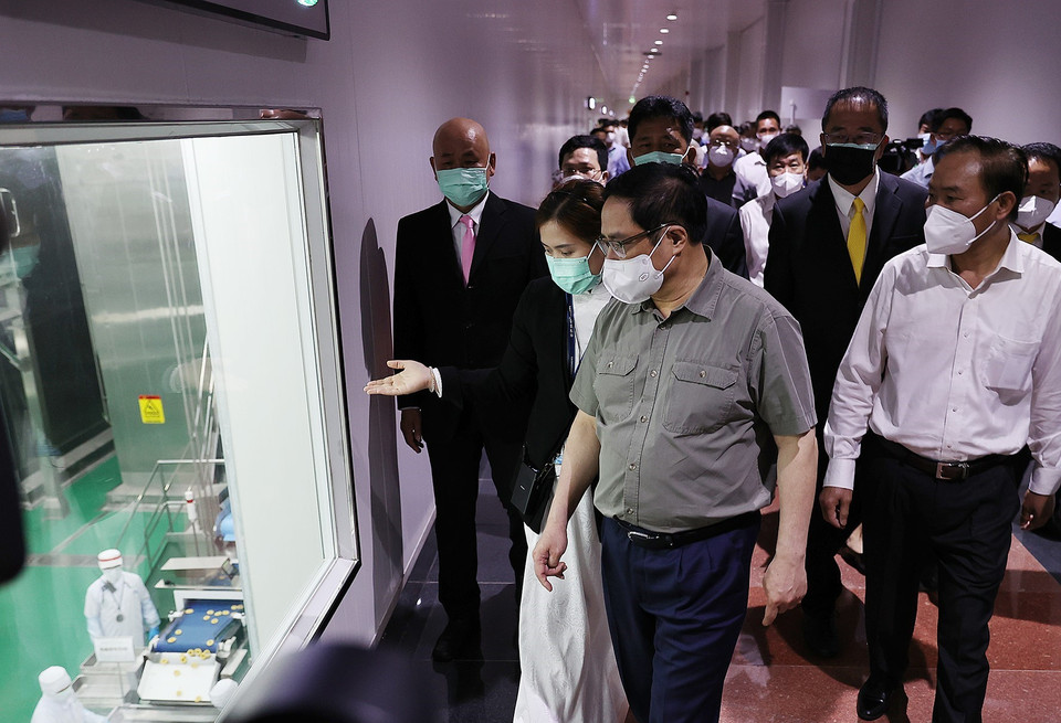 Thủ tướng Phạm Minh Chính xem quy trình chế biến thịt gia cầm xuất khẩu của Công ty trách nhiệm hữu hạn CPV Food. (Ảnh: Dương Giang/TTXVN)