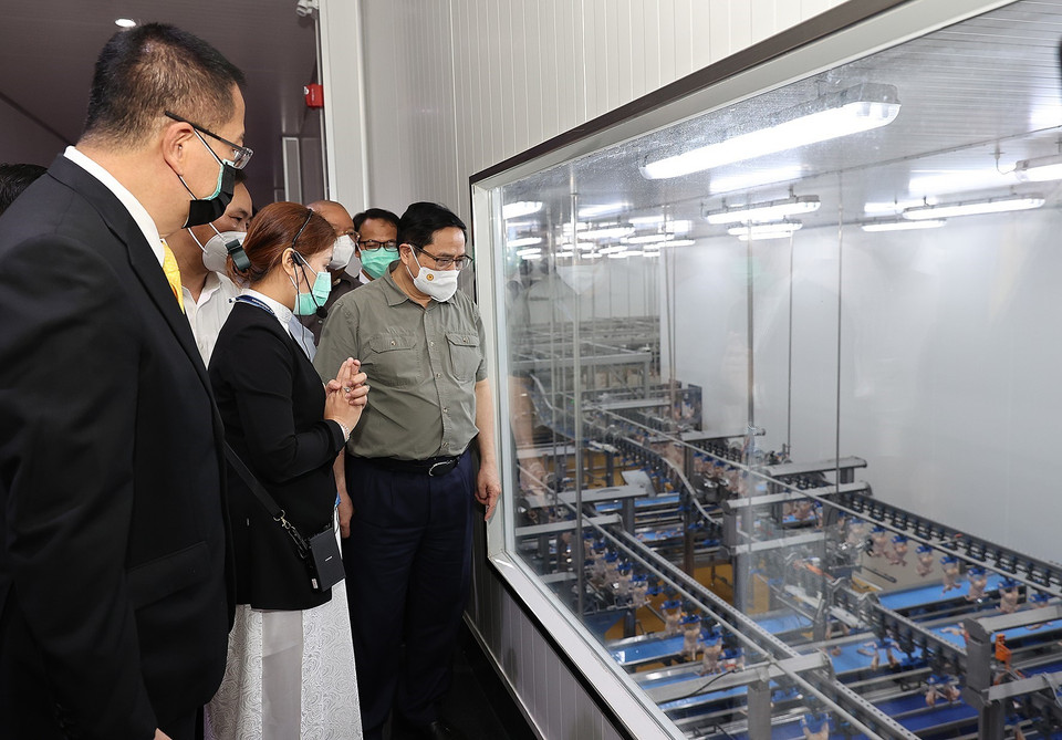 Thủ tướng Phạm Minh Chính xem quy trình chế biến thịt gia cầm xuất khẩu của Công ty trách nhiệm hữu hạn CPV Food. (Ảnh: Dương Giang/TTXVN)