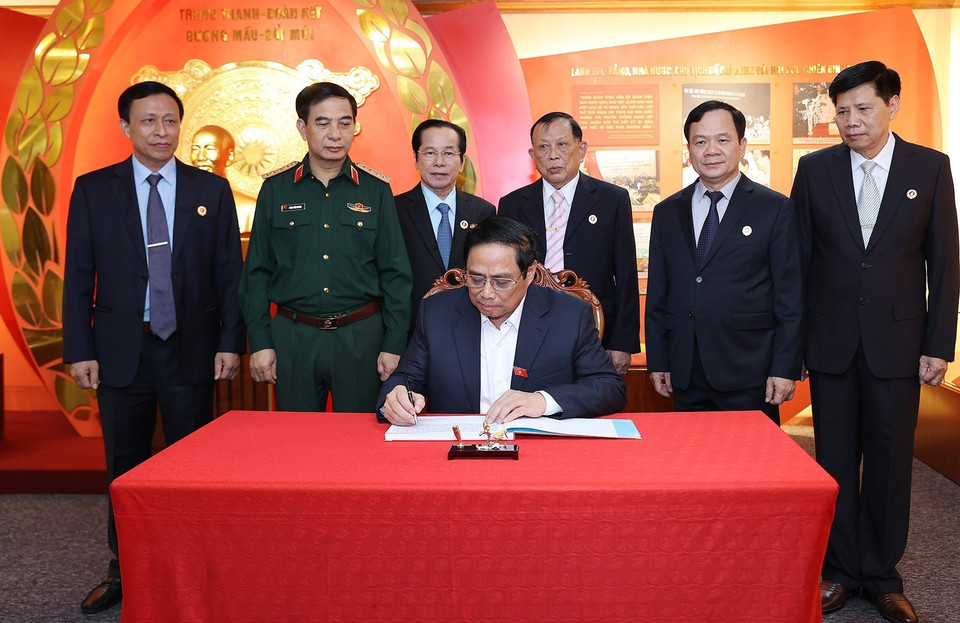 Thủ tướng Phạm Minh Chính viết lưu bút sau khi thăm Phòng truyền thống Hội Cựu chiến binh Việt Nam. (Ảnh: Dương Giang/TTXVN)