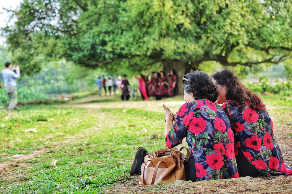 ...và thích thú xem lại những khoảnh khắc chụp cùng nhau. (Ảnh: Xuân Mai/Vietnam+)