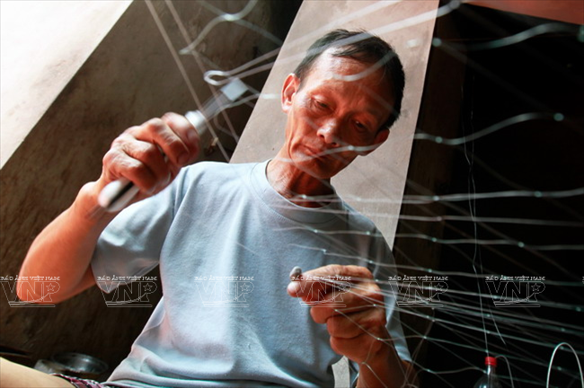 Người dân ở làng nghề Trần Phú vừa giữ được nghề đan lưới cước truyền thống lại tận dụng thời gian rảnh rỗi để có thêm thu nhập. (Nguồn: Báo ảnh Việt Nam)