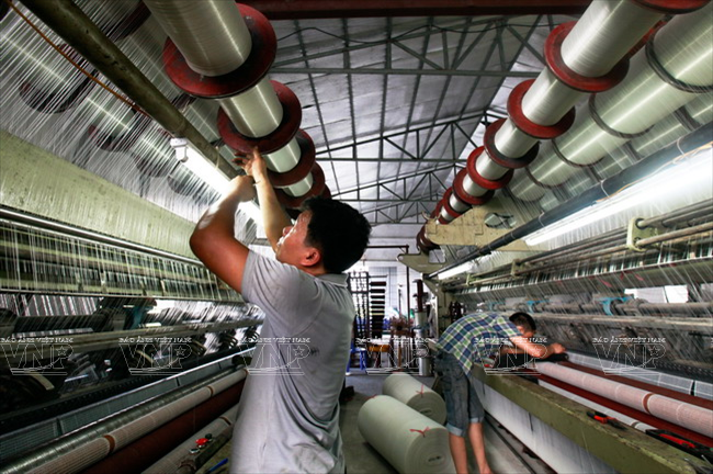 Từ nhu cầu sử dụng sản phẩm của thị trường, phương thức sản xuất lưới của làng nghề Trần Phú cũng thay đổi như xưởng đan lưới của gia đình anh Đinh Ngọc Khuyến - một trong những mô hình sản xuất lưới công nghiệp ở đây. (Nguồn: Báo ảnh Việt Nam)