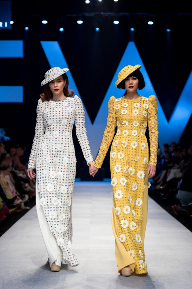 Trên phom nền cơ bản của tà áo dài truyền thống, Công Trí đã đính kết thủ công tỉ mỉ từng họa tiết cánh hoa, từng hạt cườm lấp lánh. Điểm nhấn của 2 bộ áo dài này là tay áo phồng, tôn lên vẻ đẹp bán cổ điển của thời trang thập niên trước.