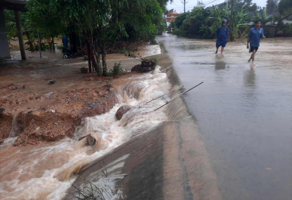 Nước lũ từ sông Hiếu tràn qua đường giao thông tại xã Cam Thủy, huyện Cam Lộ. (Ảnh: Hồ Cầu/TTXVN)