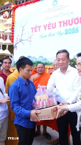 Phu nhân Tổng Bí thư, Chủ tịch nước Lào Naly Sisoulith trao phần quà yêu thương đầu tiên cho người khuyết tật. (Ảnh: Xuân Tú/TTXVN)