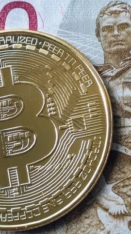 Đồng tiền ruble của Nga và đồng tiền kỹ thuật số Bitcoin. (Ảnh: Getty Images/TTXVN)