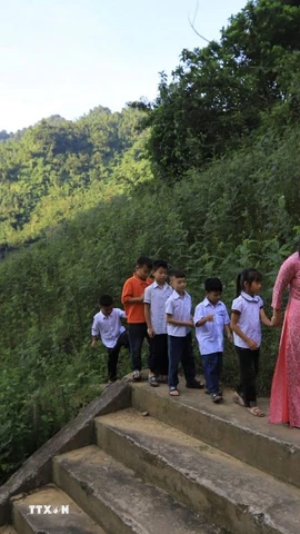 Cô giáo đón các em học sinh đến trường dự khai giảng năm học mới. (Ảnh: Trọng Đạt/TTXVN)