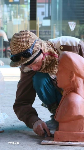 Người thợ căn chỉnh lại bức tượng truyền thần trước khi chuyển sang công đoạn đúc sản phẩm. (Ảnh: Công Luật/TTXVN)