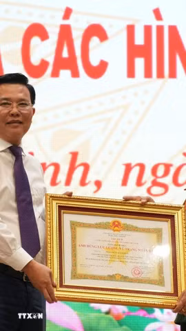 Ông Nguyễn Thanh Hải, Phó Bí thư Tỉnh ủy, Chủ tịch Ủy ban Mặt trận Tổ quốc Việt Nam tỉnh Tây Ninh, trao Danh hiệu Anh hùng lực lượng vũ trang của Chủ tịch nước cho bà Phan Thị Út. (Ảnh: Thanh Bình/TTXVN)