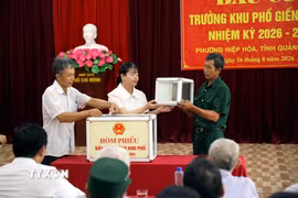 Đại diện cử tri hộ gia đình khu phố Giếng Khe, phường Hiệp Hòa, tỉnh Quảng Ninh cùng kiểm tra hòm phiếu trước khi bầu cử. (Ảnh: Đức Hiếu/TTXVN)
