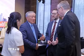 Phó Thủ tướng Thường trực Nguyễn Hòa Bình trao đổi với các đại biểu tại hội nghị. (Ảnh: Trần Việt/TTXVN)
