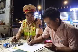 Lực lượng Cảnh sát giao thông trạm Đồng Phú lập biên bản, xử lý xe khách vi phạm giao thông. (Ảnh: Đậu Tất Thành/TTXVN)