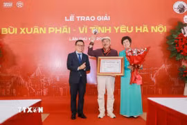 Nhà báo Lê Quốc Minh, Ủy viên Trung ương Đảng, Phó Trưởng Ban Tuyên giáo và Dân vận Trung ương và Nhà báo Vũ Việt Trang, Tổng Giám đốc TTXVN trao Giải thưởng Lớn-Vì tình yêu Hà Nội cho Nhạc sỹ Trần Tiến. (Ảnh: Phan Phương/TTXVN)