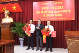 Trưởng Ban Tổ chức Trung ương Lê Minh Hưng trao quyết định và tặng hoa cho tân Phó Trưởng Ban Tuyên giáo Trung ương và Bí thư Thành ủy Cần Thơ. (Ảnh: Ngọc Thiện/TTXVN)