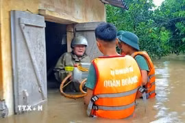 Cán bộ, chiến sỹ Sư đoàn 325 hỗ trợ nhân dân trên địa bàn phường Chũ. (Ảnh: Danh Lam/TTXVN)