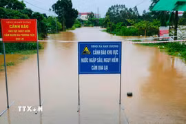 Lực lượng chức năng đặt biển cảnh báo tại các khu vực bị ngập, chia cắt do nước lũ. (Ảnh: Đồng Thúy/TTXVN)