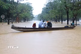 Nước ngập sâu, người dân Huế phải di chuyển bằng thuyền. (Ảnh: Nguyên Lý/TTXVN)