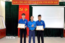 Thừa ủy quyền của Ban Bí thư Trung ương Đoàn, Phó Bí thư Tỉnh đoàn Quảng Trị Nguyễn Quốc Toản trao tặng Huy hiệu “Tuổi trẻ dũng cảm” cho đoàn viên Võ Hoàng Vũ và Nguyễn Võ Huy Công. (Ảnh: TTXVN phát)