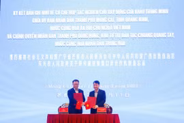 Chủ tịch UBND thành phố Móng Cái (Việt Nam) Hồ Quang Huy và Thị trưởng chính quyền nhân dân thành phố Đông Hưng (Trung Quốc) Lý Kiện trao đổi các nội dung thúc đẩy hợp tác hữu nghị và ký kết Bản ghi nhớ. (Ảnh: Lệ Hằng/TTXVN phát)