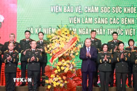 Tổng Bí thư Tô Lâm tặng hoa chúc mừng đội ngũ giáo sư, bác sỹ Bệnh viện Trung ương Quân đội 108. (Ảnh: Thống Nhất/TTXVN)