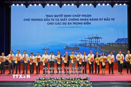 Lãnh đạo Ủy ban Nhân dân tỉnh Cà Mau trao quyết định chấp thuận chủ trương đầu tư và giấy chứng nhận đăng ký đầu tư cho các dự án trọng điểm. (Ảnh: Huỳnh Anh/TTXVN)