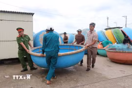 Hàng trăm phương tiện thuyền thúng được di dời lên bờ kè ứng phó với bão số 12. (Ảnh: Phạm Cường/TTXVN)