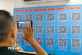 Người dân sử dụng mã QR để tra cứu thông tin thủ tục hành chính tại điểm hỗ trợ chuyển đổi số cộng đồng. (Ảnh: Trung Nguyên/TTXVN)
