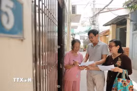 Đại diện các tổ dân phố đến từng nhà để lấy ý kiến nhân dân về phương án sắp xếp đơn vị hành chính hồi tháng 4/2025. (Ảnh: Minh Quyết/TTXVN)