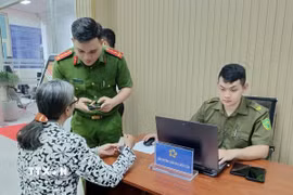 Công an hướng dẫn người dân tại bộ phận một cửa. (Ảnh: Linh Sơn/TTXVN)