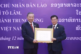 Tổng Bí thư, Chủ tịch nước Lào Thongloun Sisoulith trao tặng Huân chương Vàng Quốc gia của Nhà nước Lào cho Tổng Bí thư Tô Lâm. (Ảnh: Thống Nhất/TTXVN)